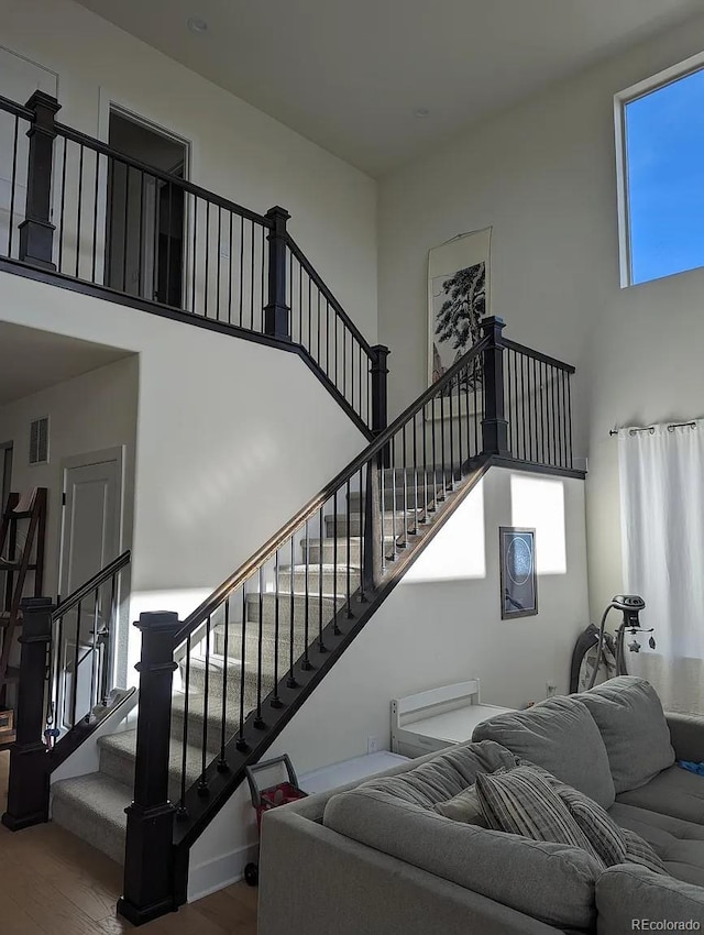 6332 E 142nd Pl, Thornton, CO 80602 - living area with a towering ceiling, wood finished floors, and stairway