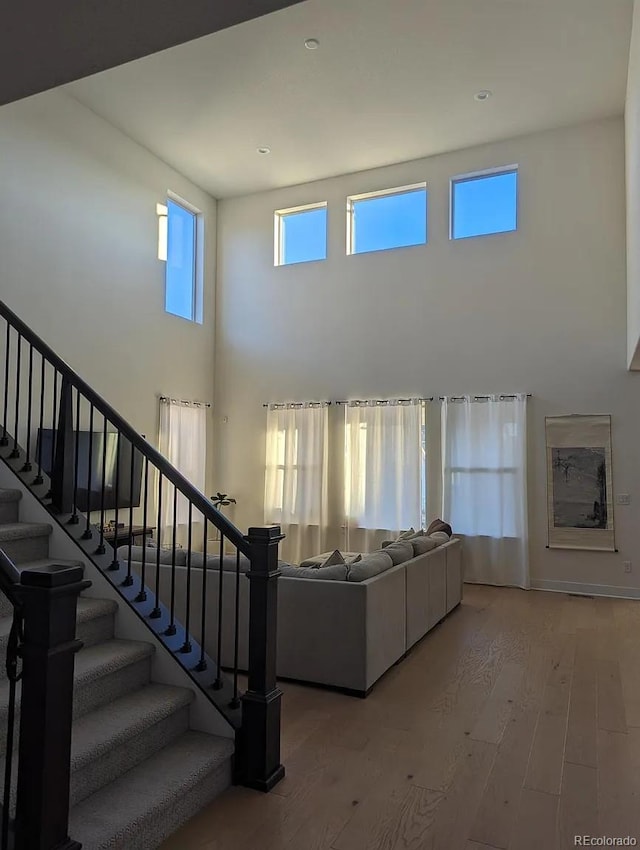 6332 E 142nd Pl, Thornton, CO 80602 - living room with wood finished floors, a towering ceiling, and stairs