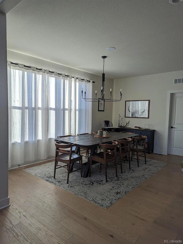 6332 E 142nd Pl, Thornton, CO 80602 - dining area with wood finished floors, a textured ceiling, and a chandelier