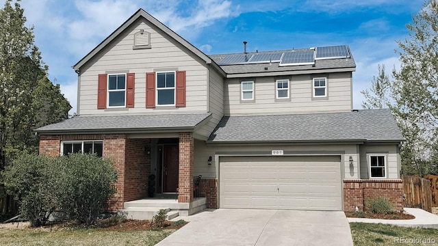 961 Stanley Ct, Erie, CO 80516 - view of front of house with brick siding, solar panels, fence, driveway, and a garage