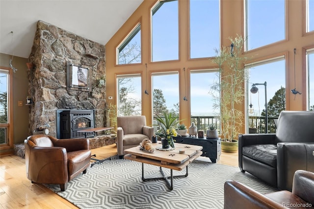 13452 Riley Peak Rd, Conifer, CO 80433 - living area featuring high vaulted ceiling, wood finished floors, and a stone fireplace