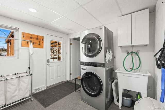 laundry area with plenty of natural light and stacked washing maching and dryer