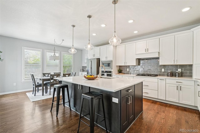 17020 E 107th Ave, Commerce City, CO 80022 - kitchen featuring stainless steel appliances, light countertops, white cabinetry, backsplash, and recessed lighting
