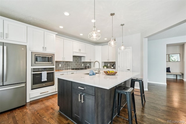 17020 E 107th Ave, Commerce City, CO 80022 - kitchen featuring stainless steel appliances, white cabinetry, backsplash, light countertops, and recessed lighting
