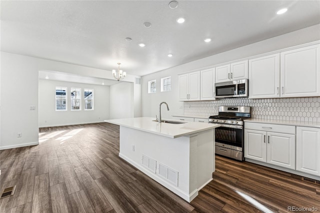 3295 N Coolidge Way, Aurora, CO 80019 - kitchen with appliances with stainless steel finishes, a sink, decorative backsplash, a chandelier, and recessed lighting