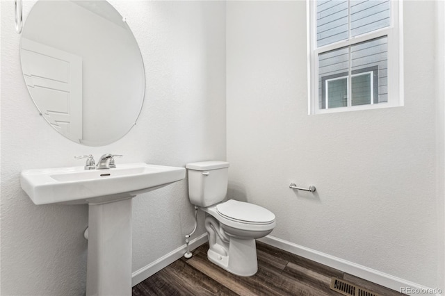 3295 N Coolidge Way, Aurora, CO 80019 - bathroom featuring baseboards, wood finished floors, and toilet