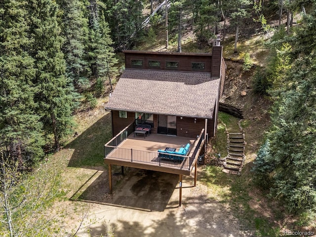 28272 Shadow Mountain Dr, Conifer, CO 80433 - back of house with stairway, a wooden deck, a shingled roof, a chimney, and a view of trees