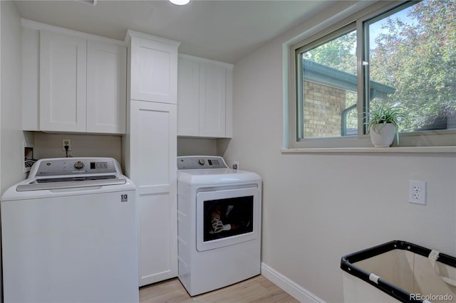 8043 S Zephyr St, Littleton, CO 80128 - washroom featuring washer and clothes dryer, cabinet space, light wood-style floors, and baseboards