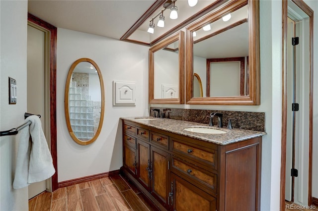 8043 S Zephyr St, Littleton, CO 80128 - full bathroom with baseboards, double vanity, and wood finished floors