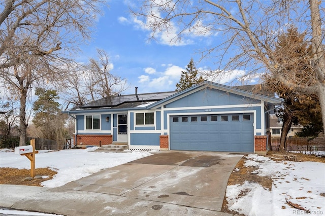 single story home featuring brick siding, an attached garage, fence, and roof mounted solar panels