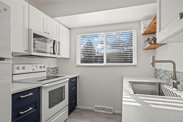 kitchen with open shelves, light countertops, white electric range, stainless steel microwave, and visible vents