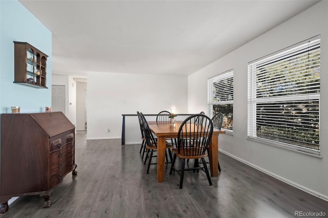 dining area with a fireplace, baseboards, and wood finished floors