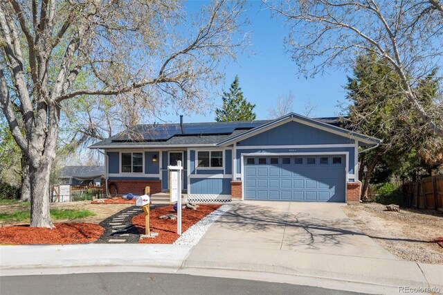 16933 E Bethany Pl, Aurora, CO 80013 - ranch-style house featuring fence, solar panels, an attached garage, concrete driveway, and brick siding