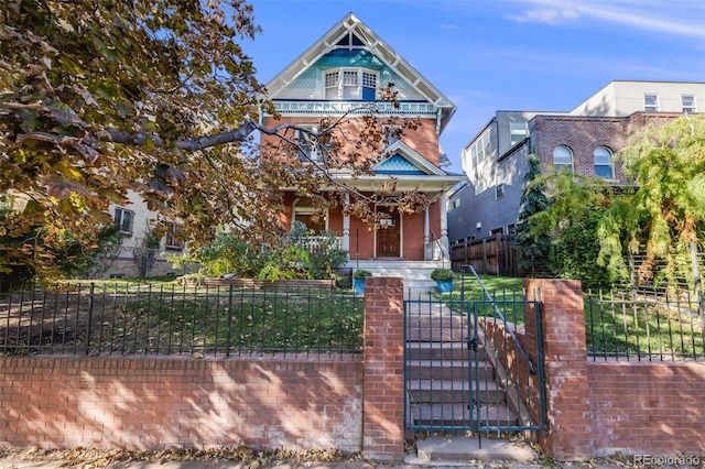 view of front facade with a fenced front yard, a gate, and a porch