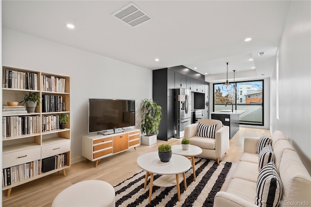 living room featuring recessed lighting, visible vents, and light wood finished floors