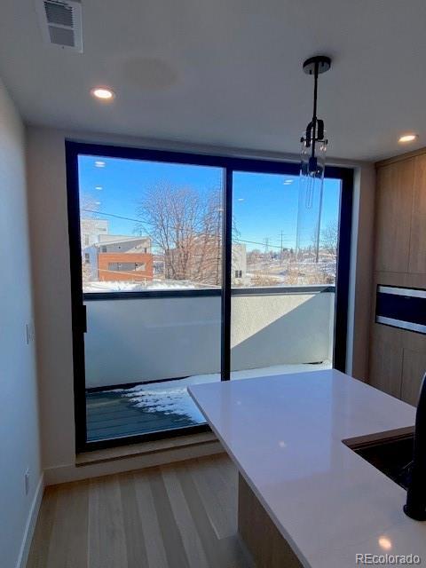 interior space featuring recessed lighting, visible vents, light wood-style flooring, and baseboards