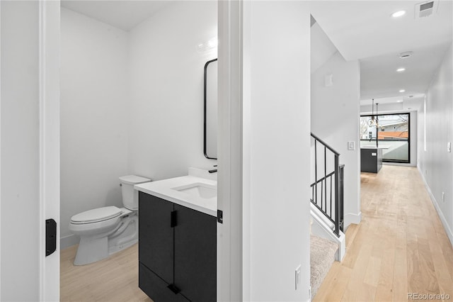 bathroom with visible vents, vanity, toilet, and wood finished floors