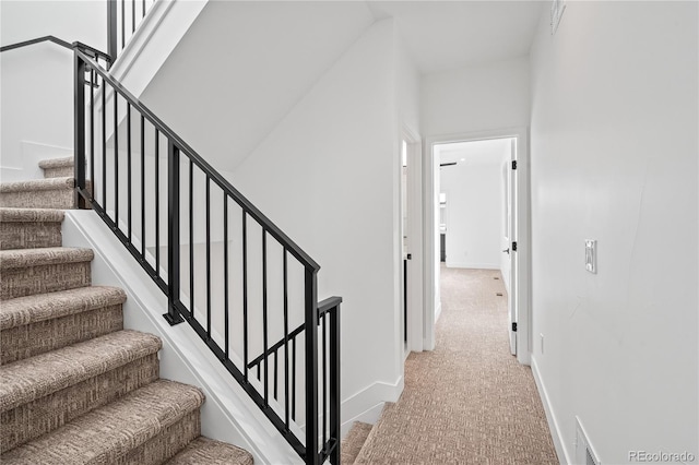 stairway featuring carpet and baseboards