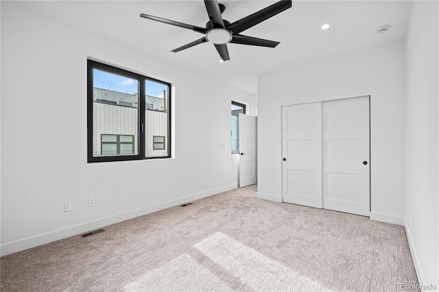 unfurnished bedroom featuring visible vents, baseboards, light colored carpet, a closet, and recessed lighting