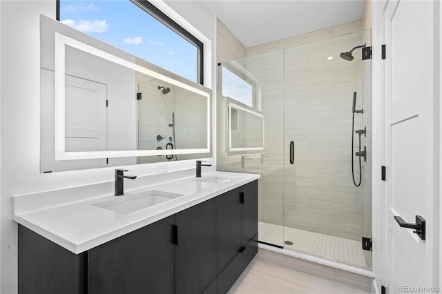 full bathroom with double vanity, a stall shower, a sink, and tile patterned floors