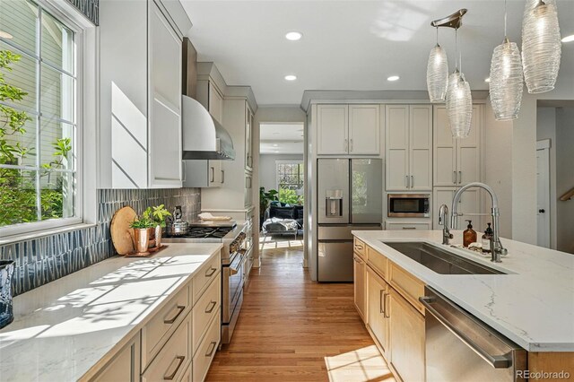 8256 E 28th Dr, Denver, CO 80238 - kitchen featuring appliances with stainless steel finishes, a sink, recessed lighting, light wood finished floors, and backsplash