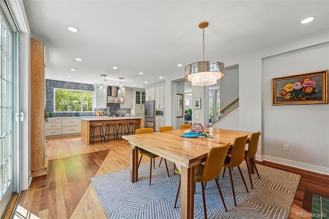 8256 E 28th Dr, Denver, CO 80238 - dining area featuring light wood-style floors, a chandelier, recessed lighting, baseboards, and stairs