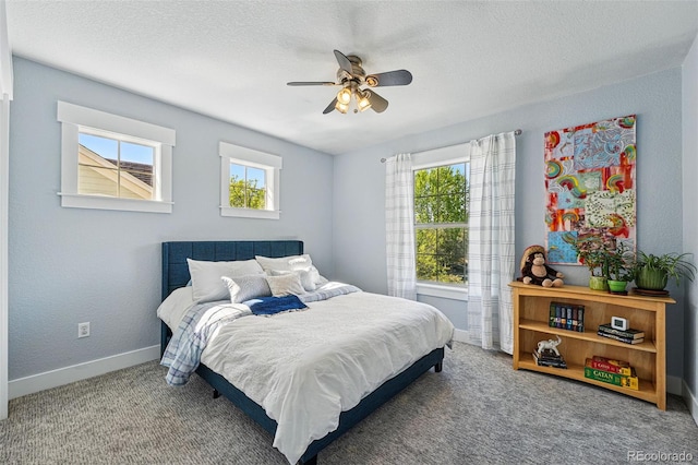 8256 E 28th Dr, Denver, CO 80238 - carpeted bedroom featuring multiple windows, baseboards, a ceiling fan, and a textured ceiling