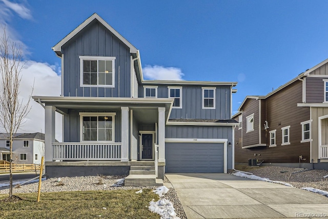 view of front of property featuring a garage, central air condition unit, and covered porch