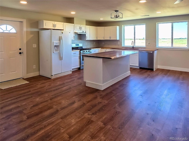 9193 US Highway 36, Joes, CO 80822 - kitchen featuring stainless steel appliances, under cabinet range hood, white cabinetry, backsplash, and dark wood-style flooring