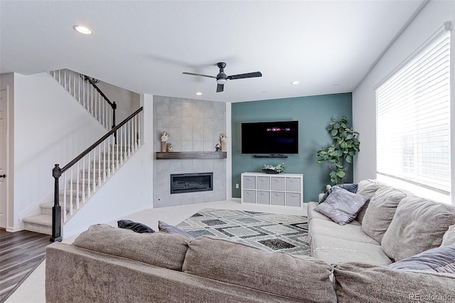9835 Uravan St, Commerce City, CO 80022 - living room with stairs, a tiled fireplace, recessed lighting, ceiling fan, and wood finished floors