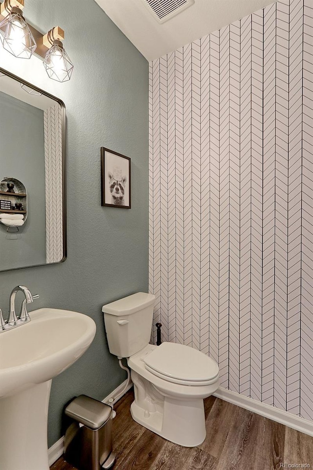 9835 Uravan St, Commerce City, CO 80022 - half bath featuring wood finished floors, toilet, and baseboards