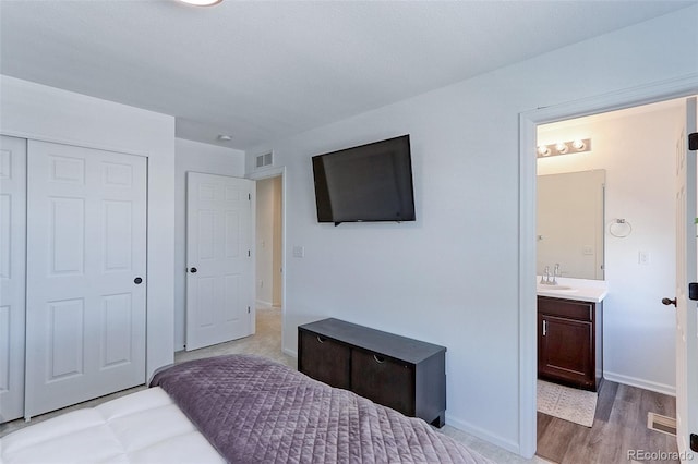 9835 Uravan St, Commerce City, CO 80022 - bedroom featuring a sink, wood finished floors, a closet, baseboards, and ensuite bathroom