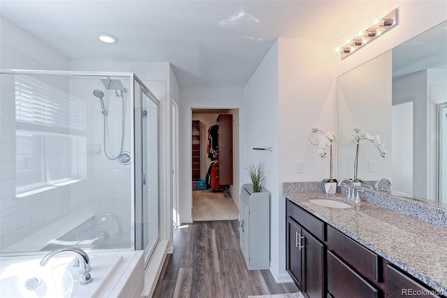 9835 Uravan St, Commerce City, CO 80022 - full bathroom with a stall shower, wood finished floors, vanity, a spacious closet, and recessed lighting
