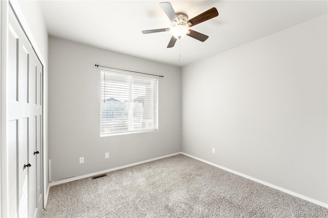 carpeted empty room featuring ceiling fan