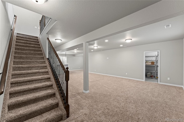 basement featuring carpet floors and a textured ceiling