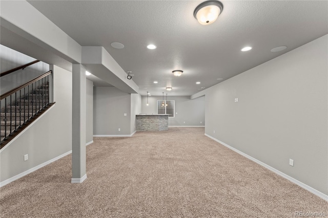 basement with light colored carpet and a textured ceiling