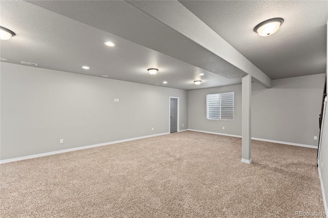 basement with carpet flooring and a textured ceiling