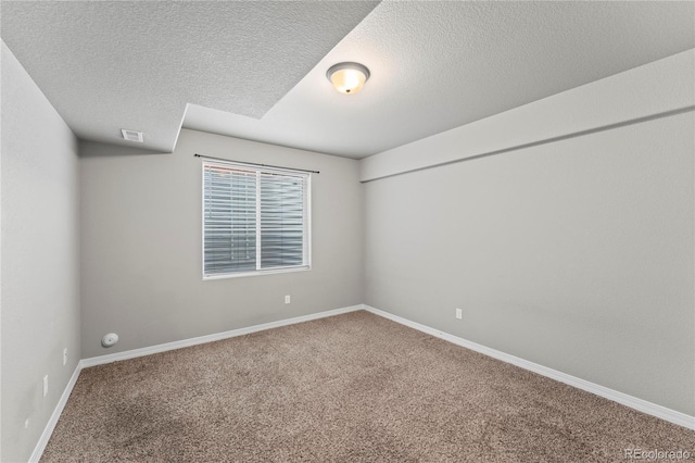 carpeted empty room featuring a textured ceiling