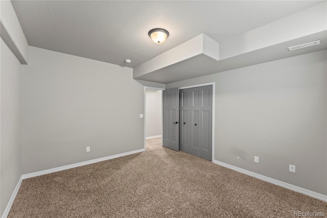 unfurnished bedroom with carpet, a textured ceiling, and a closet