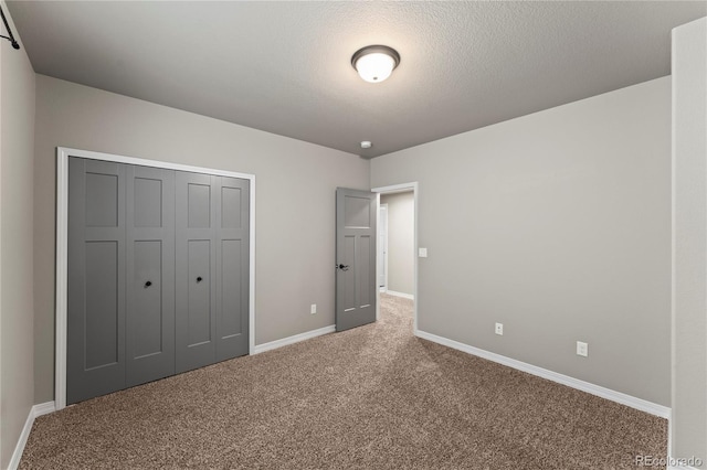 unfurnished bedroom with carpet floors, a textured ceiling, and a closet