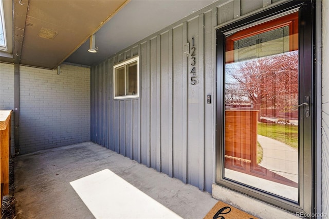 12345 W 32nd Ave, Wheat Ridge, CO 80033 - view of exterior entry with board and batten siding, brick siding, and covered porch