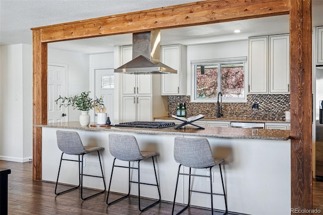12345 W 32nd Ave, Wheat Ridge, CO 80033 - kitchen featuring white cabinets, tasteful backsplash, a kitchen breakfast bar, and wall chimney exhaust hood