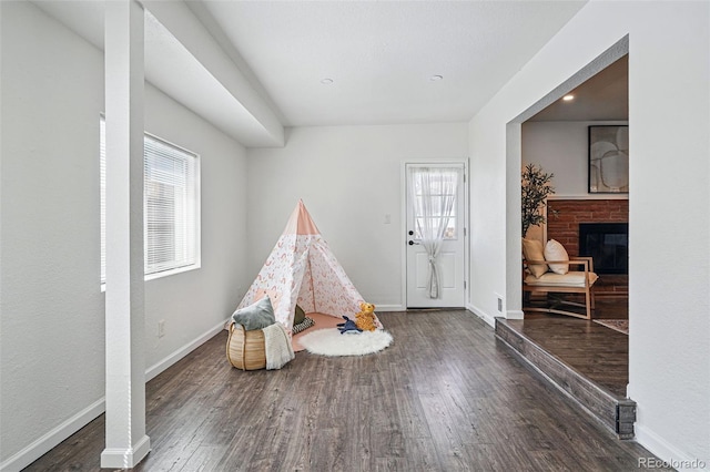 12345 W 32nd Ave, Wheat Ridge, CO 80033 - rec room featuring a brick fireplace, baseboards, and wood finished floors
