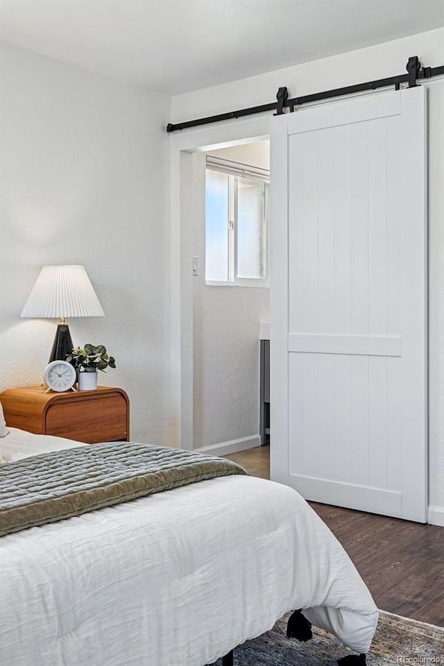 12345 W 32nd Ave, Wheat Ridge, CO 80033 - bedroom with a barn door, baseboards, and wood finished floors