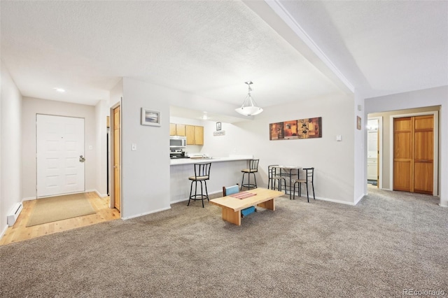 interior space with baseboard heating, a textured ceiling, and baseboards