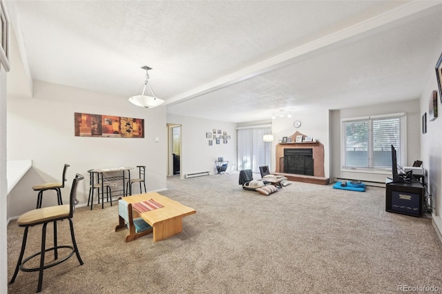 living area with a baseboard radiator, a textured ceiling, a fireplace with raised hearth, and carpet flooring