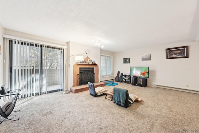 living area featuring a baseboard heating unit, carpet, and a fireplace with raised hearth