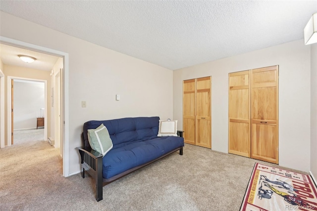 living area with light colored carpet and a textured ceiling