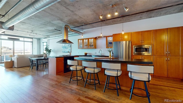 1401 Wewatta St Unit 808, Denver, CO 80202 - kitchen with stainless steel appliances, a sink, light wood-style flooring, extractor fan, and a kitchen bar