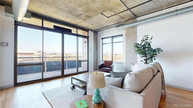 1401 Wewatta St Unit 808, Denver, CO 80202 - living room featuring wood finished floors, a wall of windows, and baseboards